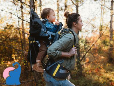 Elternteil mit Kind auf dem Rücken in einer Rückentrage während einer Wanderung