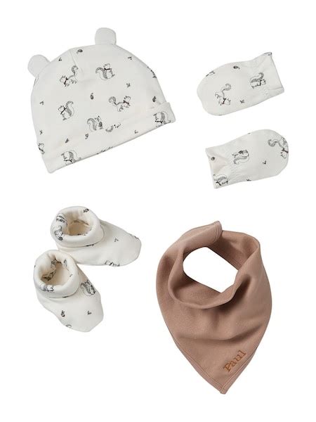 Detailaufnahme von Baby-Accessoires wie Mütze, Fäustlingen und Lauflernschuhen.
