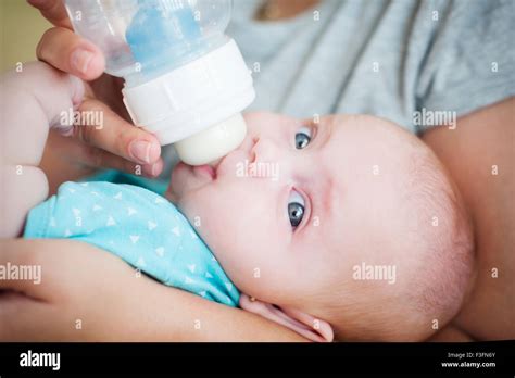 Nahaufnahme eines Babys, das glücklich aus einer Babyflasche trinkt.