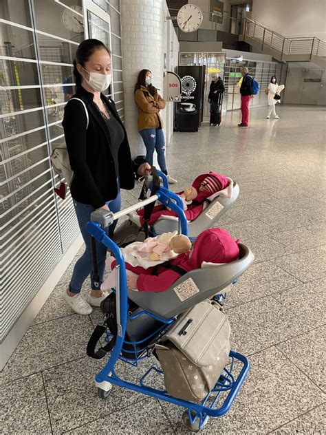 Frau mit Baby und Kinderwagen am Flughafen