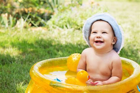Baby planscht mit Schwimmring im Wasser