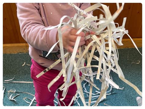 Kind trägt Papierstreifen mit Kleister auf eine Form auf