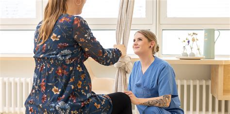 Eine Hebamme, die eine schwangere Frau tröstet.