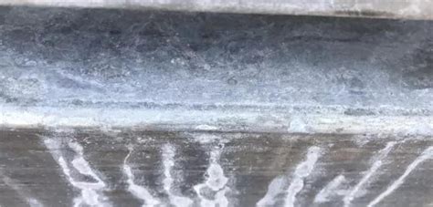 Schema, das die Entstehung von Weißrost an verzinkten Oberflächen durch Salz und Feuchtigkeit erklärt