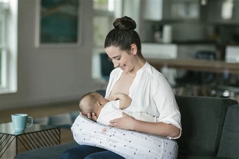 Illustration einer Hebamme, die eine Mutter beim Stillen unterstützt
