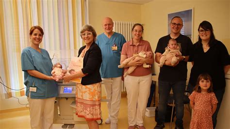 Foto einer Familie mit einem Frühchen, das von einer Neonatalbegleiterin unterstützt wird