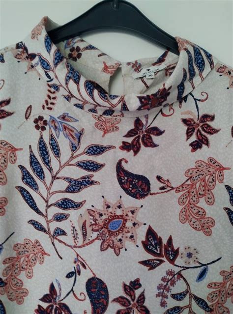 Eine Collage aus verschiedenen Kleidungsstücken für Kinder von Tom Tailor: Jeansjacke, Sweatweste, Sommerkleid, T-Shirt mit Print, Hoodie.