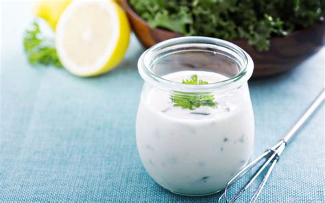 Schüssel mit frischen Kräutern, Zitrone und einer halben Schalotte für ein Dressing