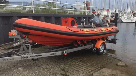 Detailaufnahme der 5-Punkt-Gurtschlitze an der Lammfell-Auflage, die die einfache und sichere Befestigung im Kinderwagen demonstriert.