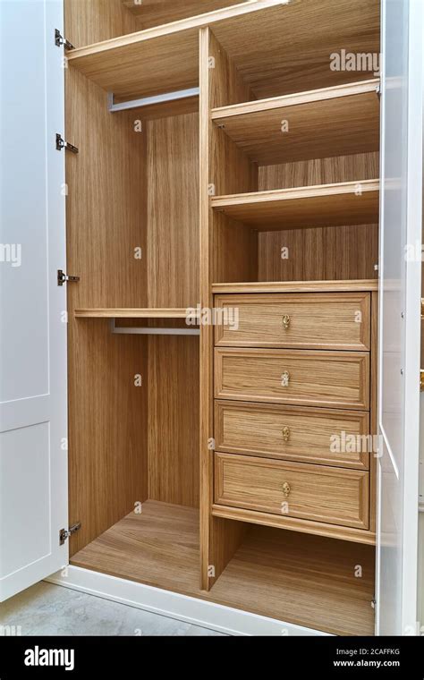 Innenansicht des Kleiderschranks mit vielen Regalböden, Schubladen und einer Kleiderstange