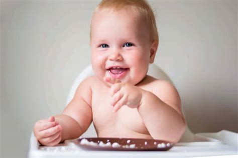 Foto von einem Baby, das mit Begeisterung Fingerfood isst.