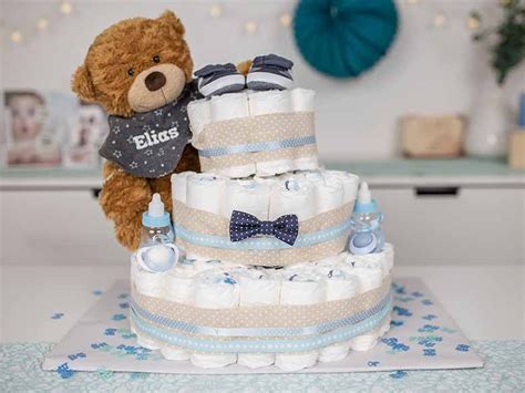 Eine Windeltorte in Blau- und Grüntönen für einen Jungen, dekoriert mit einem Teddybär