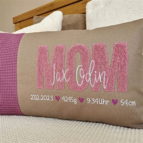 Collage aus personalisierten Babygeschenken: Kissen mit Namen, bestickte Decke, gravierter Löffel