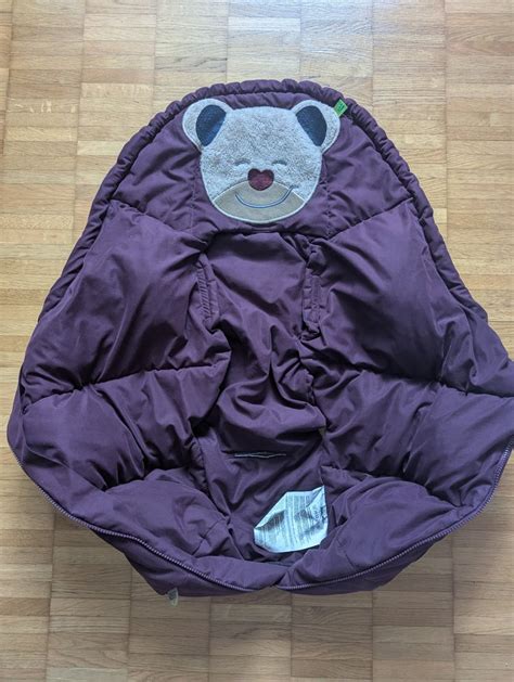 Illustration des Odenwälder Mucki Fubsack Pink mit einem Kind darin, montiert in einem Kinderwagen