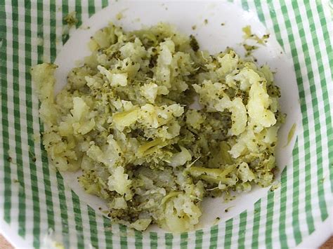 Ein appetitlicher Brokkoli-Kartoffel-Brei in einer Babyschüssel, garniert mit einem Hauch von Öl.