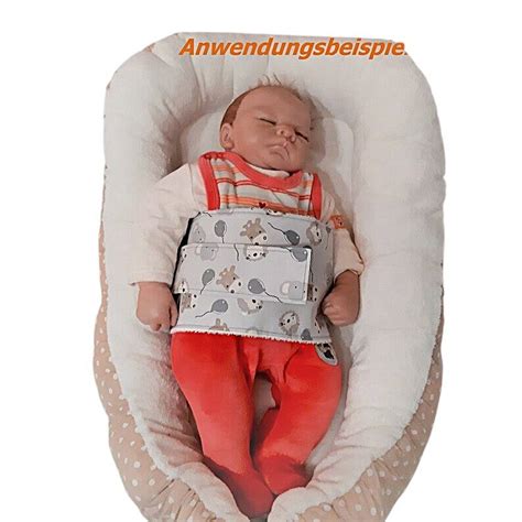 Baby mit Wärmekissen auf dem Bauch zur Linderung von Blähungen