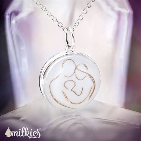 Eine junge Mutter hält stolz ein selbstgemachtes Schmuckstück aus Muttermilch in den Händen.