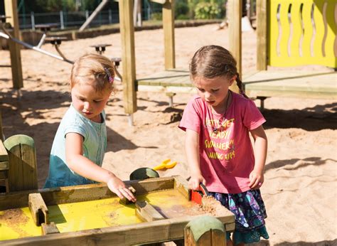Kinder spielen mit Wasser und Sand auf einem naturnahen Abenteuerspielplatz
