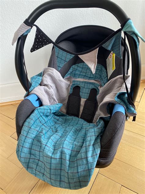 Fertige Einschlagdecke für einen Baby-Autositz, gefaltet, um die Materialien und das Design zu zeigen.