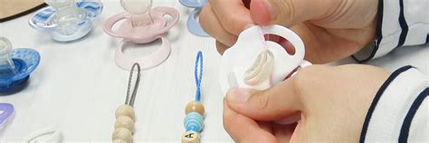 Detailansicht eines Schnullers mit Clip und Teddybärkopf