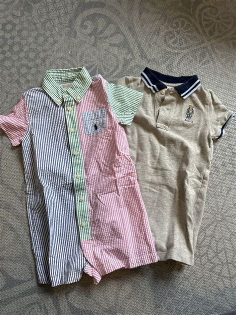 Verschiedene Kleidungsstücke für Mädchen von Ralph Lauren: Bodys, Strampler, Kleider, Polo-Shirts in verschiedenen Farben und Mustern.