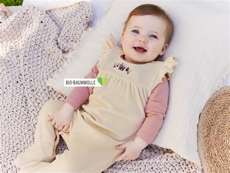 verschiedene Nicki-Strampler und Overalls für Babys in unterschiedlichen Farben und Größen