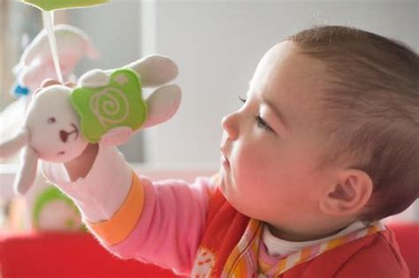 Illustration: Baby beim Greifen nach einem Spielzeug