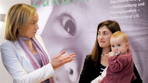 Fotografie: Eine Familienhebamme spricht mit einer jungen Mutter