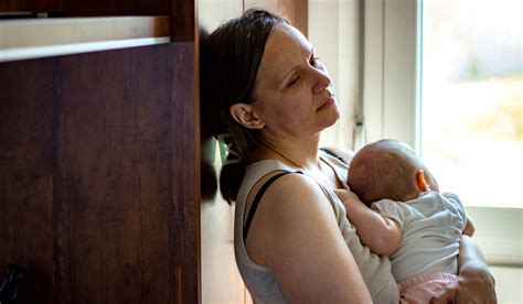 Eine erschöpfte Mutter, die ihr Babyphone beobachtet.