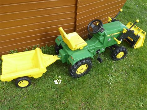 Detailaufnahme eines Kindes, das seinen Trettraktor liebevoll reinigt.