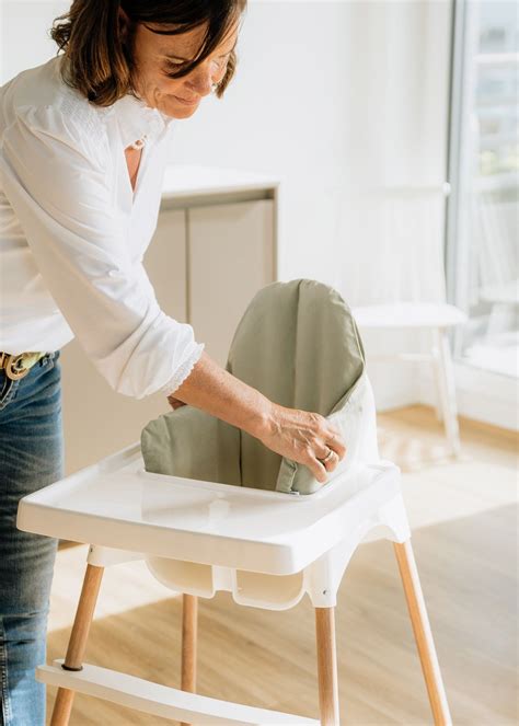 Ein Baby sitzt im IKEA Antilop Hochstuhl mit dem optionalen Stützkissen.