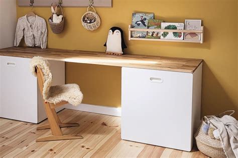 Ein selbstgebauter Kinderschreibtisch, der auf einem IKEA SMÅSTAD Schrank basiert, mit einer Holzplatte und farbigen Griffen.