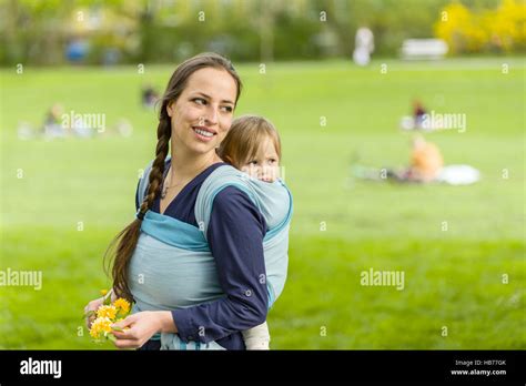 Kind wird von der Mutter in einem elastischen Tragetuch getragen