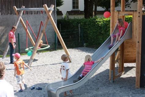 Kinder beim Toben auf einem Spielplatz, eine Szene, die auf mögliche Zahnunfälle hindeutet.
