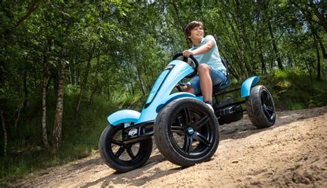 Ein Kind fährt begeistert mit dem HIGHPER Elektro Gokart auf einer Wiese.