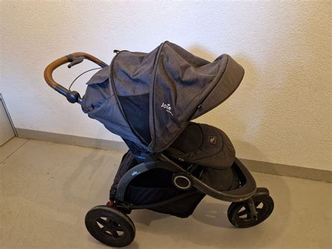 Übersichtsfoto des Joie Crosster Kinderwagens mit Kind und Gepäck