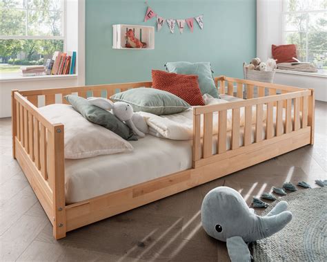 Kind, das sicher aus einem niedrigen Bodenbett aufsteht