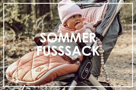 Ein Kind, das gemütlich in einem bunten Sommer-Fußsack im Kinderwagen sitzt.
