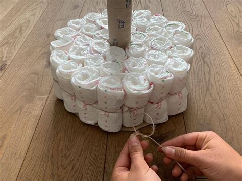Übersicht der Materialien, die für das Basteln einer Windeltorte benötigt werden: Windeln, Gummibänder, Bänder, Babykleidung und Spielzeug.