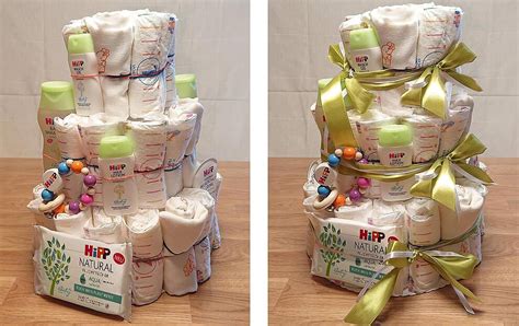 Detailaufnahme, wie gerollte Windeln zu einer Etage einer Windeltorte zusammengefügt werden, fixiert mit einem großen Gummiband.