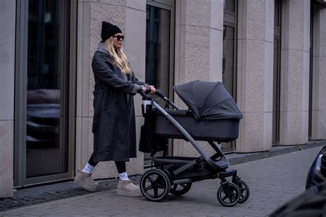 Ein Elternpaar testet einen Joolz Kinderwagen mit seinem Baby.