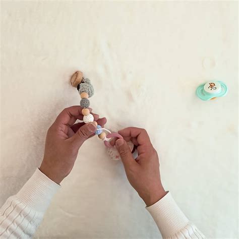 Schema zur Befestigung einer Schnullerkette an einem Schnuller mit Ring