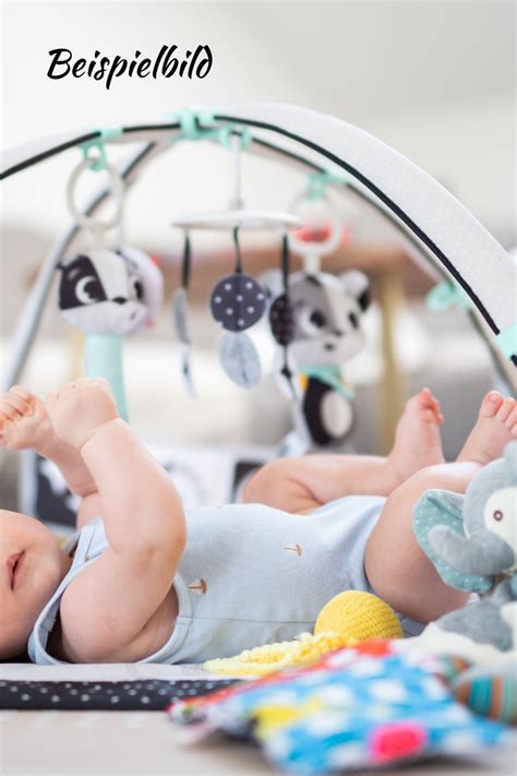 Kind mit Down-Syndrom spielt mit einem hölzernen Spielbogen, der als Lauflernhilfe dient.