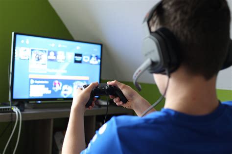 Ein Jugendlicher mit Down-Syndrom spielt begeistert an einer Spielekonsole.