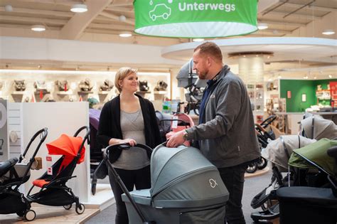 Ausstellung von Babymöbeln im BabyOne Geschäft, darunter Wickelkommoden und Betten