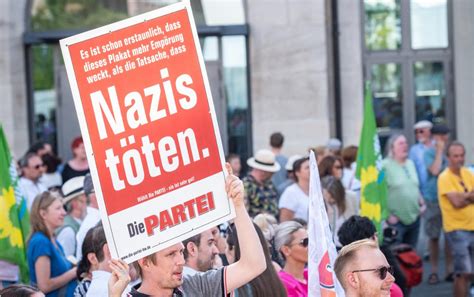 Menschen halten Plakate mit Slogans gegen Rechtsextremismus