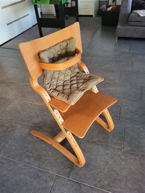 Collage von verschiedenen Hochstuhl-Zubehörteilen wie Sitzkissen, Tabletts und Neugeborenenaufsätzen.