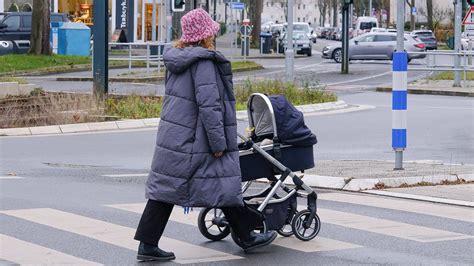 Elternteil schiebt einen höhenverstellbaren Kinderwagen