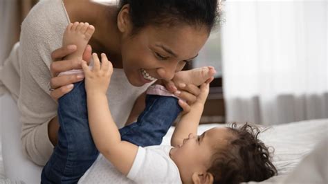 Eltern spielen mit Babys auf Matten in einem warmen Raum