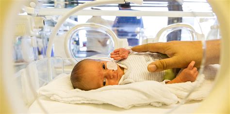 Neugeborenes Baby in einer Inkubator-ähnlichen Umgebung, überwacht von medizinischem Personal